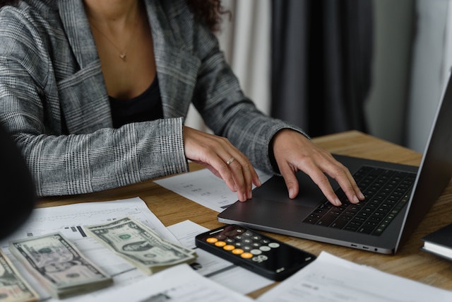 a person on a laptop with money next to them